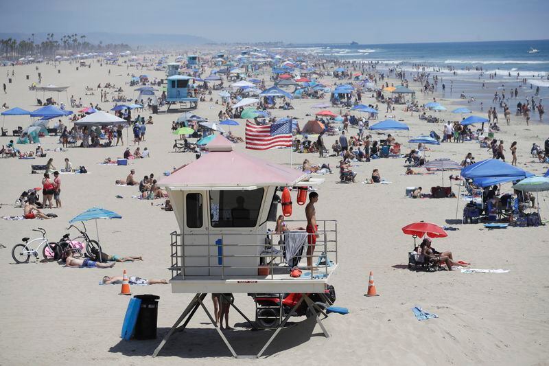 A lifeguard keeps watch over a packed beach Saturday in Huntington Beach, California.