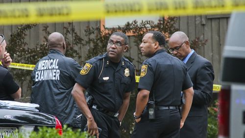 In this file photo, DeKalb County police officials confer at the scene where two women were found shot dead on May 19, 2014.