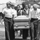 Casket containing Michael Cameron McIntosh, 23, the 25th victim in Atlanta?s string of slayings of young black is carried by members of the Guardian Angels and relatives during funeral services in Atlanta, Monday, April 27, 1981. His mother, Mrs. Hazel Matthews, third from left, follows the casket. (AP Phtoo/Sebo)