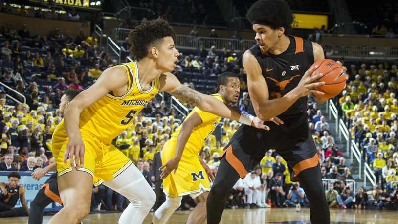 Michigan forward D.J. Wilson (5) defends Texas center Jarrett Allen, right, in the first half of an NCAA college basketball game in Ann Arbor, Mich., Tuesday, Dec. 6, 2016. (AP Photo/Tony Ding)