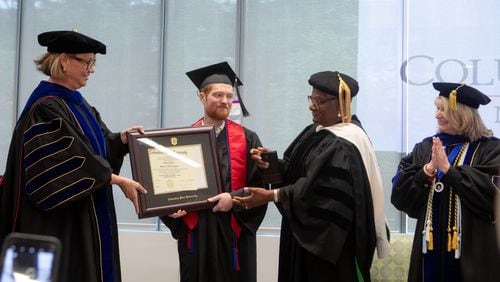 Columbus State University President Stuart Rayfield (left) presents Grant Martin his diploma. Annice Yarber-Allen, dean of the College of Letters and Science, and Margie Yates, dean of the College of Education and Health Professions (right), were also in attendance Saturday.