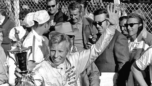 Pete Hamilton, of Charlotte, N.C., waves a trophy in Victory Lane after winning the Daytona 500 auto race at Daytona Beach, Fla. Hamilton, won four career Cup races, died Wednesday, March 22, 2017. He was 74. (AP Photo/CS, File)