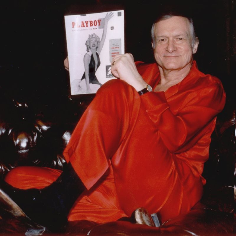 Hugh Hefner relaxes in red satin pajamas with the first copy of Playboy magazine in his Holmby Hills estate in Los Angeles in this 1996 photo from his 70th birthday celebration. Photo: AP