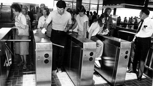 June 30, 1979 - DECATUR, GA - AVONDALE MARTA STATION - First passengers come through, or like the girl on right, climb over, the fare gates. Some of the turnstiles stuck and people had to step over them to get in while they were trying to be repaired. (Nancy Mangiafico/AJC staff) 1979