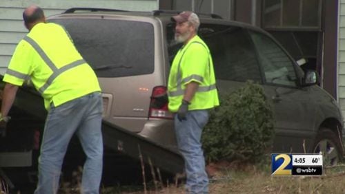 Workers remove a van after it crashed into a house in Fayette County.