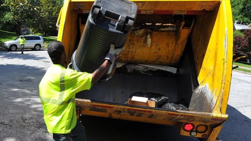 DeKalb County sanitation worker Larry Wyatt dumps trash into the truck in a file photo.