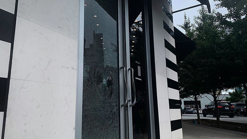 A man is in custody after a stray bullet shattered the front door of a Buckhead storefront Tuesday afternoon.