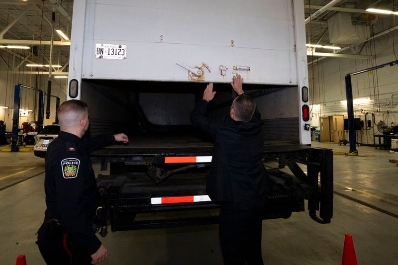 Police officers open the back of a recovered truck during a press conference regarding Project 24K a joint investigation into the theft of gold from Pearson International Airport, in Brampton, Ontario, on Wednesday, April 17, 2024. (Arlyn McAdorey/The Canadian Press via AP)