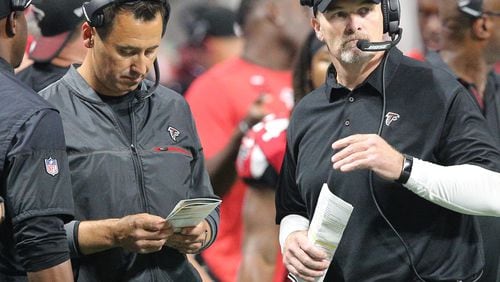 Falcons offensive coordinator Steve Sarkisian and head coach Dan Quinn confer on the sidelines against the Packers in a NFL football game on Sunday, September 17, 2017, in Atlanta.    Curtis Compton/ccompton@ajc.com