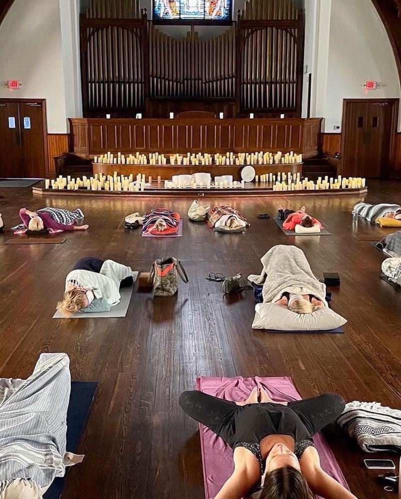 At a candlelight sound bath session, guests relax in Savasana (corpse pose) as certified sound healer, Rebecca Turk,  plays quartz crystal bowls tuned to the seven-point chakra system. Image credit: Rebecca Turk