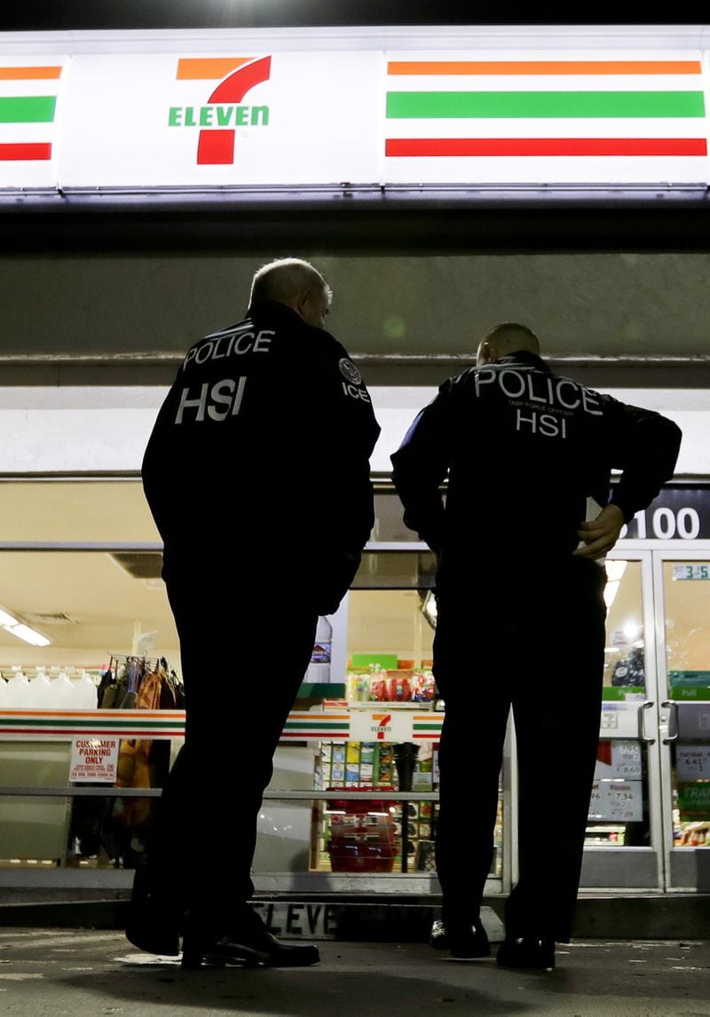 U.S. Immigration and Customs Enforcement agents serve an employment audit notice at a 7-Eleven convenience store Wednesday in Los Angeles. (AP Photo/Chris Carlson)