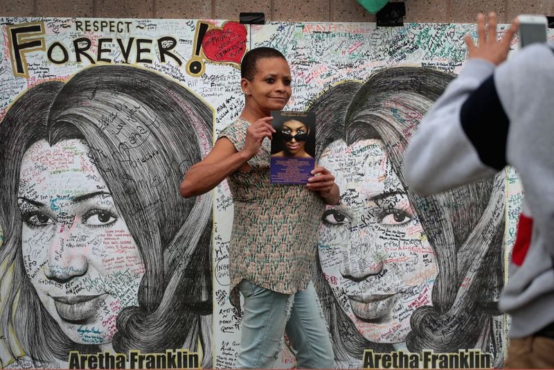 DETROIT, MI - AUGUST 29:  Pamela Bolton poses for pictures next to posters of Aretha Franklin created by artist Mark Gaines outside of the Charles H. Wright Museum of African-American History where the Queen of Soul lies in repose on August 29, 2018 in Detroit, Michigan. Franklin's funeral will be held Friday at Greater Grace Temple.  (Photo by Scott Olson/Getty Images)