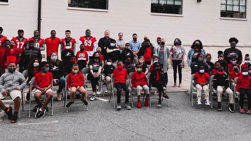 The students from Downtown Academy couldn't all fit in a photo with Georgia football players Lewis Cine (16), Nakobe Dean (17), Kearis Jackson (10), receivers coach Cortez Hankton, Jake Camarda (90) and Jamaree Salyer (69) when they dropped off a check for $100,000 on Thursday. The money was the proceeds from Saturday's G-Day Intrasquad game, which will be attended by more the 20,000 fans on Saturday, April 17, 2021. (Photo by UGA Athletics)