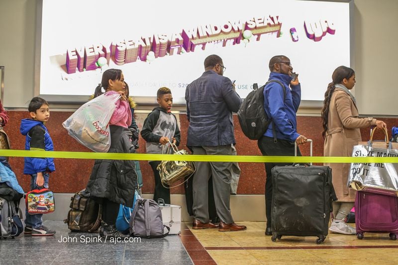 Passengers stood in line at Hartsfield-Jackson International Airport early Monday. More than 400 flights have been canceled so far. (JOHN SPINK / JSPINK@AJC.COM)