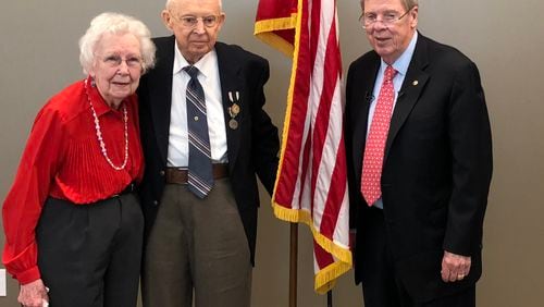 Ralph G. Rumsey (middle) was presented with a Prisoner of War Medal by U.S. Senator Johnny Isakson, on right, as his wife Ruby and other family and friends looked on.