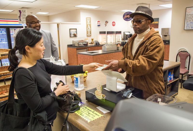 Ginger Gibson and Maurice Broughton buy food from Eddie Mial in the basement of the DeKalb County Superior Court in Decatur. Mial, who is blind, is among 75 visually impaired people who operate small businesses through a state program. (Photo by Phil Skinner)