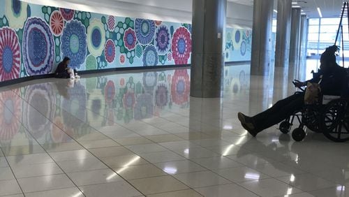 The decorative wall at the center of Concourse C at Hartsfield-Jackson International Airport is where a food court is supposed to be, but contracting delays leave it empty.