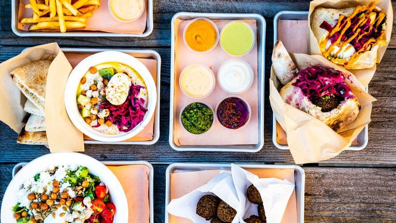 A selection of dishes from Falafel Nation, including (clockwise from top): fries with harissa aioli, accouterments, falafel pita, sabich, two falafel side orders, chopped salad and the hummus bowl. Falafel Nation is a sister restaurant to Aziza. CONTRIBUTED BY HENRI HOLLIS
