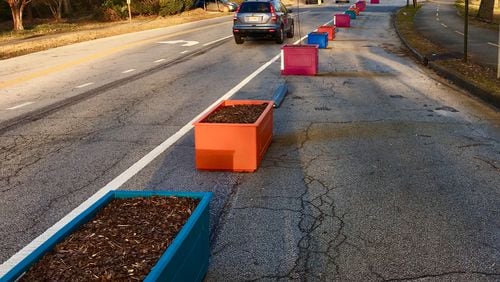 A portion of the 197 planter boxes lining West Howard Avenue looking east toward the complicated Atlanta Avenue/railroad tracks/College Avenue intersection. Those boxes currently empty will receive a wildflower mix in the coming weeks. The Atlanta-Stone Mountain PATH trail is on the far right. Bill Banks for the AJC