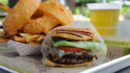 BurgerFi's Brisket Burger: a double 28-day dry-aged ground brisket, Swiss cheese, blue cheese, lettuce, tomato, pickles and BurgerFi sauce. Served with Cry & Fries (onion rings with fries) and a draft beer.