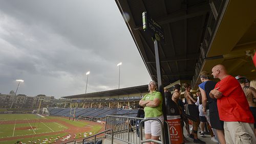 Football fans wait under shelter during a thunderstorm prior to the start of Tucker and Archer's game at Coolray Field in Lawrenceville during the Corky Kell Classic Friday, August 23, 2019. PHOTO/Daniel Varnado