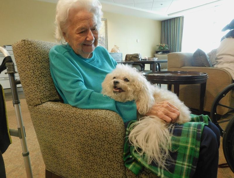 Carolyn Barlow enjoys holding therapy dog Shayna. Happy Tails volunteer Gerry Serotte brought Shayna to a pet therapy visit at Lenbrook senior community in Atlanta. Photo contributed by Lenbrook.