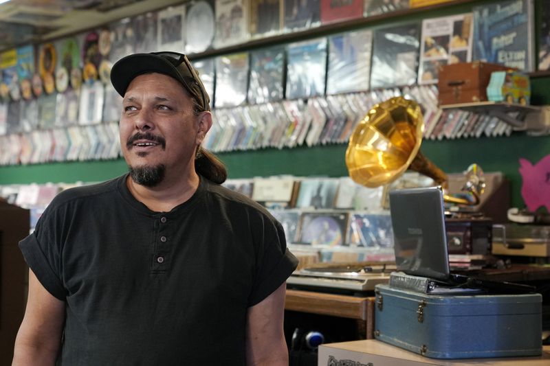 Tim Stamper, owner at Tracks In Wax record shop, pauses in his shop, Thursday, April 18, 2024, in Phoenix. Special LP releases, live performances and at least one giant block party are scheduled around the U.S. Saturday as hundreds of shops celebrate Record Store Day amid a surge of interest in vinyl and the day after the release of Taylor Swift's latest album. (AP Photo/Ross D. Franklin)
