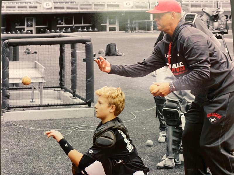 This is photo of lifelong catcher Scott Stricklin (R) working with his son Cale in a drill on the wall of Foley Field after a Georgia baseball practice a few years ago. (Family photo)