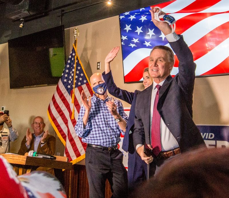 Florida Senator Rick Scott, from left, supports Senators Kelly Loeffler, center, and David Perdue, right, at a rally on Friday, November 13, 2020 at Black Diamond Grill in Cumming, GA.  Both Georgia candidates head to a run-off election in January.  (Jenni Girtman for The Atlanta Journal Constitution)