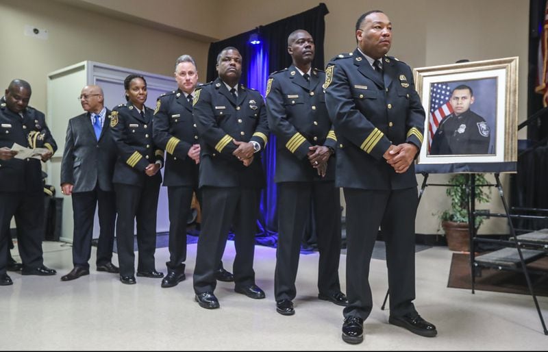 DeKalb County Police command staff stand near the portrait of slain Officer Edgar Flores, 24 as they wait to congratulate graduates at the DeKalb County 114th Police Academy graduation ceremony on Friday, Dec. 14, 2018 at the Manuel J. Maloof Auditorium in Decatur. Flores, a rookie who had been with the department a little over a year, was killed the line of duty on Thursday, Dec. 13, 2018. He had great promise, DeKalb County CEO Michael Thurmond said. 