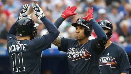 Braves' Johan Camargo  is congratulated by Ender Inciarte after hitting a grand slam in the second inning against the Toronto Blue Jays June 19, 2018, at Rogers Centre in Toronto.
