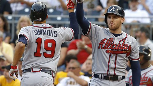 Atlanta Braves' Andrelton Simmons is greeted by on-deck batter Freddie Freeman after hitting a solo home run in the first inning of the Braves' 7-3 in over the Pirates Monday, Aug. 18, 2014, in Pittsburgh.