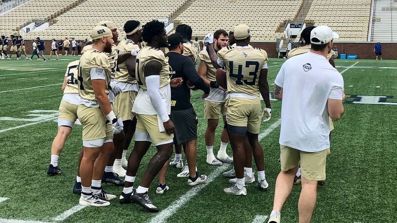 Georgia Tech linebackers break a huddle during their practice at Bobby Dodd Stadium Aug. 19, 2022. Position coach Jason Semore (black t-shirt) is in the middle of the huddle. (AJC photo by Ken Sugiura)