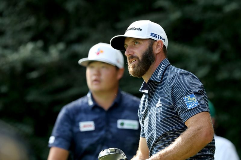 Dustin Johnson (right) reacts after teeing off on the 14th hole next to Sungjae Im during the final round of the Masters Tournament Sunday, Nov. 15, 2020, at Augusta National. (Curtis Compton / Curtis.Compton@ajc.com)