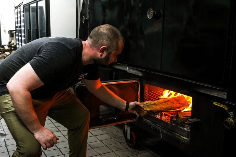 Piedmont Kitchen partner Byrd Henriksen fires up the water pan smoker in the company's commercial kitchen space. Courtesy of Piedmont Kitchen Co.