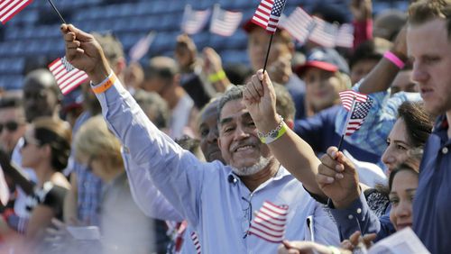 September 16, 2016 -  Atlanta -  Newly sworn in citizens cheer and wave flags after taking their oath of citizenship.   The "New Americans Project, "a voter registration effort organized by the League of Women Voters of Georgia,  over the past three years has managed to register more than 15,000 newly minted citizens. On Friday,  volunteers were staffing a table at Turner Field during a naturalization ceremony for 755 people -- with hopes that many of them stop by and sign up to become first-time voters in their adopted country.   BOB ANDRES  /BANDRES@AJC.COM