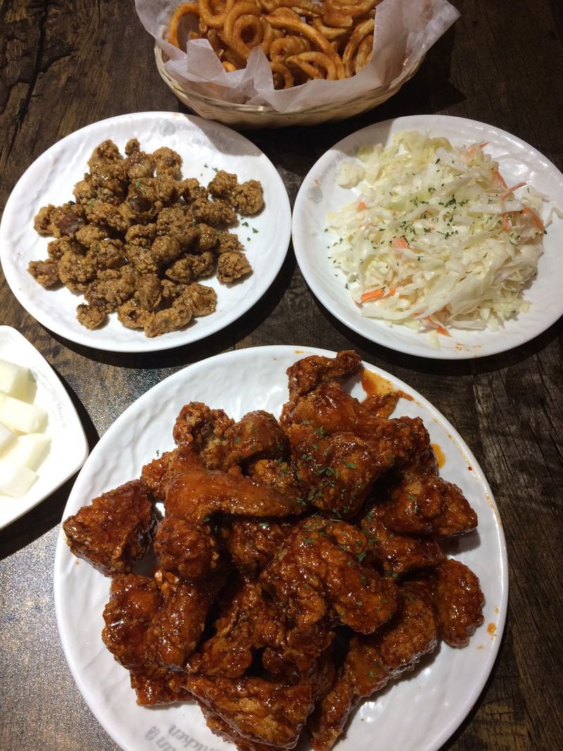 Choong Man Chicken is a new Korean fried chicken spot in Duluth. Shown here is a whole “garlic spicy” fried bird, with chicken gizzards, curly fries and coleslaw. CONTRIBUTED BY WENDELL BROCK