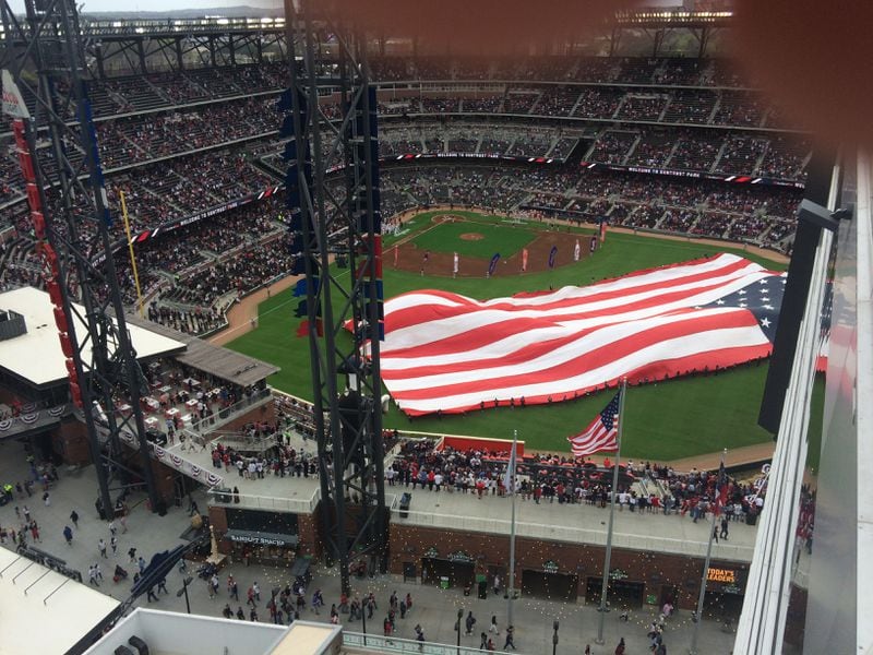Watching a giant American flag being unfurled as part of the pre-game festivities from the balcony/terrace of my room at the Omni Hotel at the Battery Atlanta. Jill Vejnoska/AJC