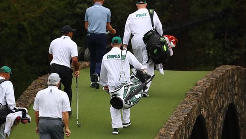 Fred Couples, Tiger Woods and Justin Thomas cross the Ben Hogan Bridge to the 12th green during their practice round for the Masters at Augusta National Golf Club on Wednesday, April 6, 2022, in Augusta, Georgia. (Curtis Compton/The Atlanta Journal-Constitution/TNS)