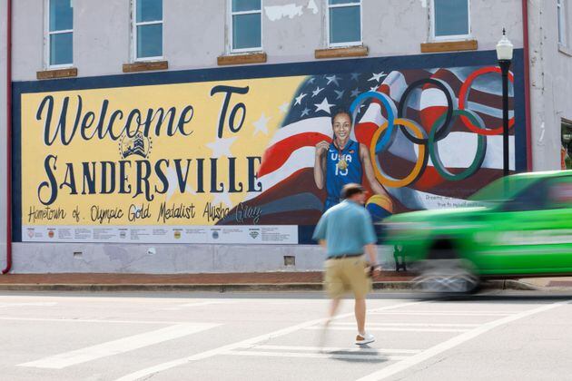 A pedestrian crosses North Harris Street in downtown Sandersville, where a mural is dedicated to Olympic gold medalist and Atlanta Dream player Allisha Gray on Tuesday, April 14, 2024. (Miguel Martinez / AJC)