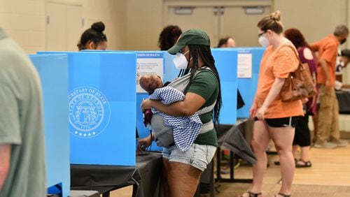 Gwinnett County residents, including Latanya Adams (center) with her 4-month-old son Princeton, cast their votes at the Pinckneyville Community Center in Norcross during the Georgia primary June 9. (Hyosub Shin / Hyosub.Shin@ajc.com)