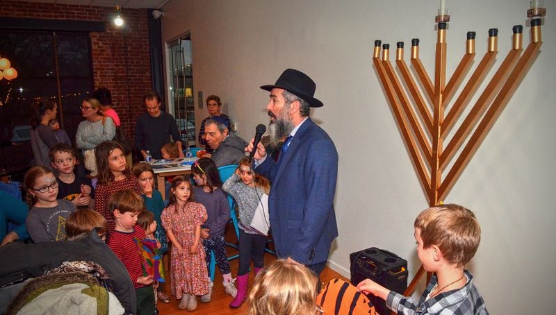 191222 Atlanta, Ga: Rabbi Eliyahu Schusterman has a short quiz with the children on meanings just prior to the Menorah lighting ceremony. Menorah lighting and celebration sponsored by Chabad Intown and MJCAA Day Camps. Music, entertainment, Dreidels, doughnuts, hot latkes, gelt drop and more. Children who RSVP will recieve and Chanukah gift. All photos taken Sunday 12/22/2019 at Chabad Intown, along the Beltline in Atlanta, Ga. (Photo credit Chris Hunt Photography) for 122319hanukkah