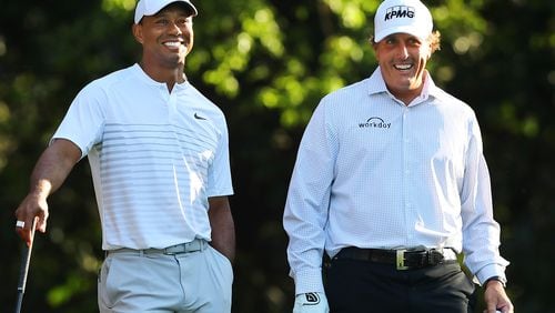 Tiger Woods and Phil Mickelson lighten it up during their Tuesday practice round for the Masters. (Curtis Compton/ccompton@ajc.com)