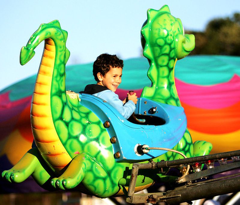 Six-year-old Alex Blecker, of Roswell, enjoys a dragon ride at the Cumming Country Fair & Festival, held at the Cumming Fairgrounds. The fair will run all this weekend.