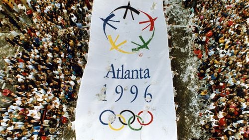 An Atlanta 1996 banner makes its way north along Peachtree Street Monday during an Olympic Parade celebrating Atlanta's winning bid for the 1996 Games. Joey Ivansco/AJC File