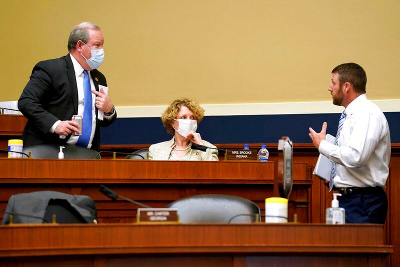 Rep. Larry Bucshon, R-Ind., right, speaks to Reps. Susan Brooks, R-Ind., and Markwayne Mullin. R-Okla., during a House Energy and Commerce Subcommittee on Health hearing on protecting scientific integrity in response to the coronavirus outbreak on Thursday, May 14, 2020, on Capitol Hill in Washington. (Greg Nash/Pool via AP)