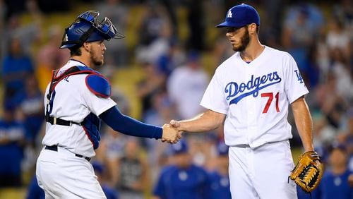 Los Angeles Dodgers catcher Yasmani Grandal, left, and relief pitcher Josh Ravin congratulate each other after the Dodgers defeated the Philadelphia Phillies 9-4 in a baseball game, Monday, Aug. 8, 2016, in Los Angeles. (AP Photo/Mark J. Terrill)