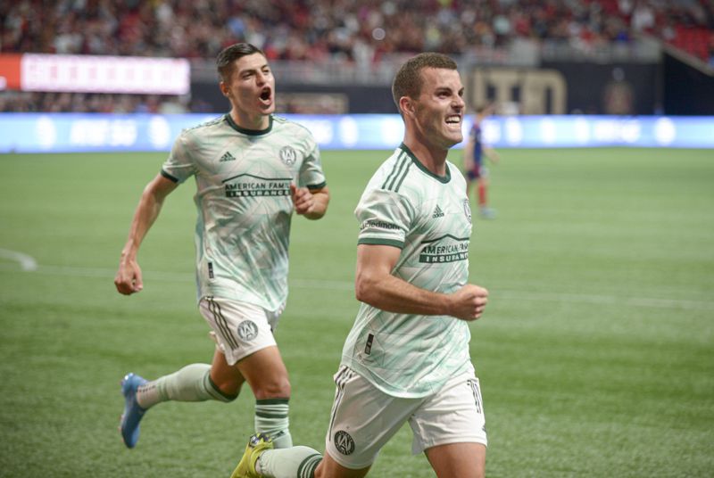 Atlanta United forward Ronaldo Cisneros (29) celebrates with defender Brooks Lennon (11) after Lennon scores the fourth and final goal against Chicago Fire FC Saturday, May 7, 2022 at the Mercedez-Benz Stadium. (Daniel Varnado/For the Atlanta Journal-Constitution)