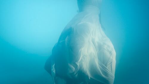 Stock image of a woman wearing a wedding dress underwater.