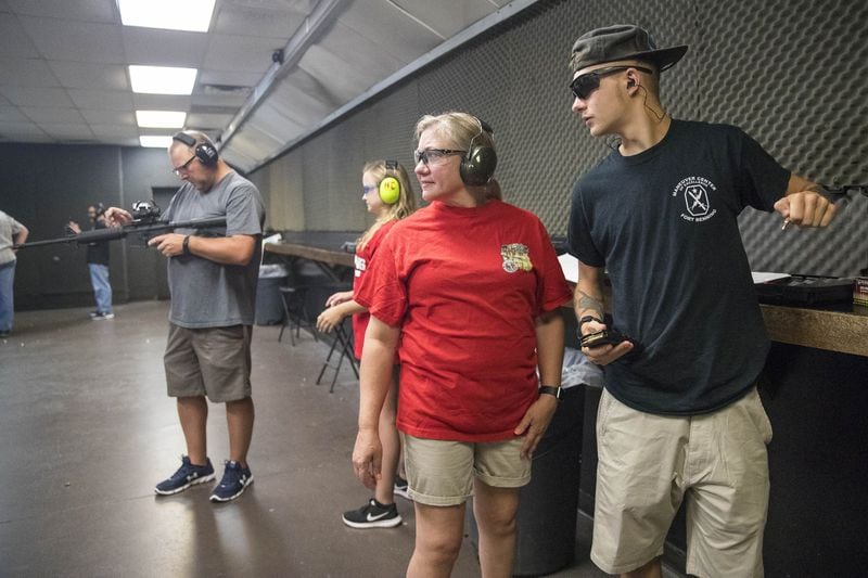 Dalton Peters, 20, right, talks with his mother, Lori, as they practice in the gun range at Hi-Caliber Firearms in Canton, Wednesday, June 27, 2018. (ALYSSA POINTER/ALYSSA.POINTER@AJC.COM)